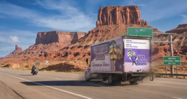 617 Boston Movers truck driving on a highway past desert rock formations